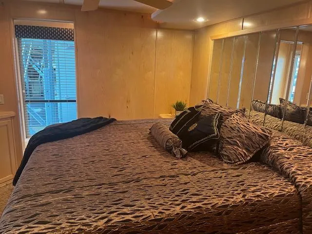 Slide: The Image of Luxurious bedroom in a 2007 Thoroughbred houseboat with elegant bedding and mirrored wall. - 18