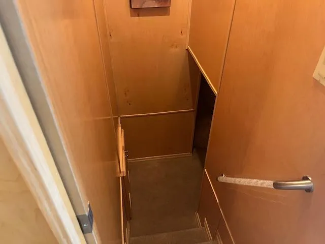 Slide: The Image of Narrow staircase inside a 2007 Thoroughbred houseboat with wooden walls and handrail. - 22