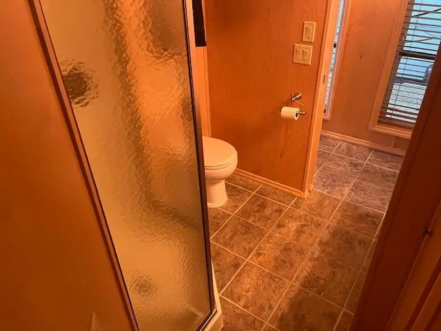 Slide: The Image of 2007 Thoroughbred Houseboat bathroom with shower, toilet, and tiled floor. - 24