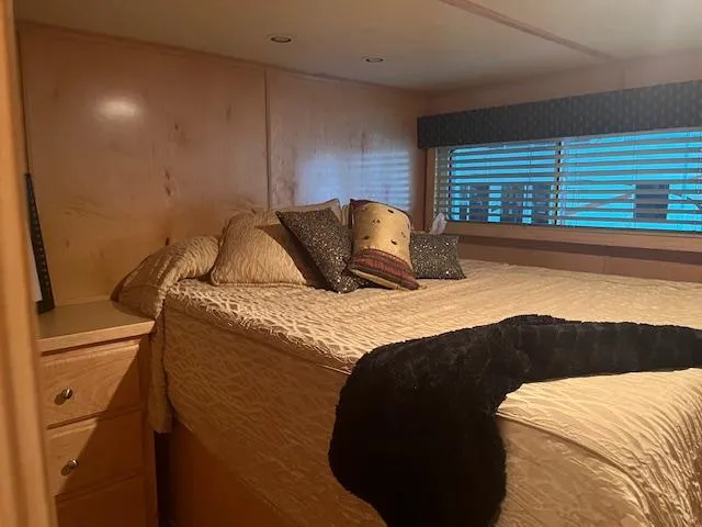 Slide: The Image of Cozy bedroom in a 2007 Thoroughbred houseboat with a large bed and decorative pillows. - 27
