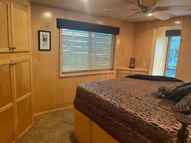 Slide: The Image of Cozy bedroom in a 2007 Thoroughbred houseboat with wooden interiors and a large bed. - 29