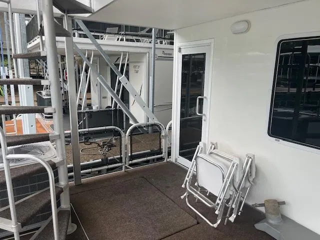 Slide: The Image of 2007 Thoroughbred houseboat deck with stairs, door, and folded chairs. - 30