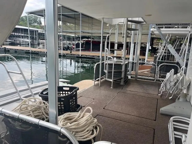 Slide: The Image of 2007 Thoroughbred Houseboat docked, featuring deck area with ropes and seating. - 38