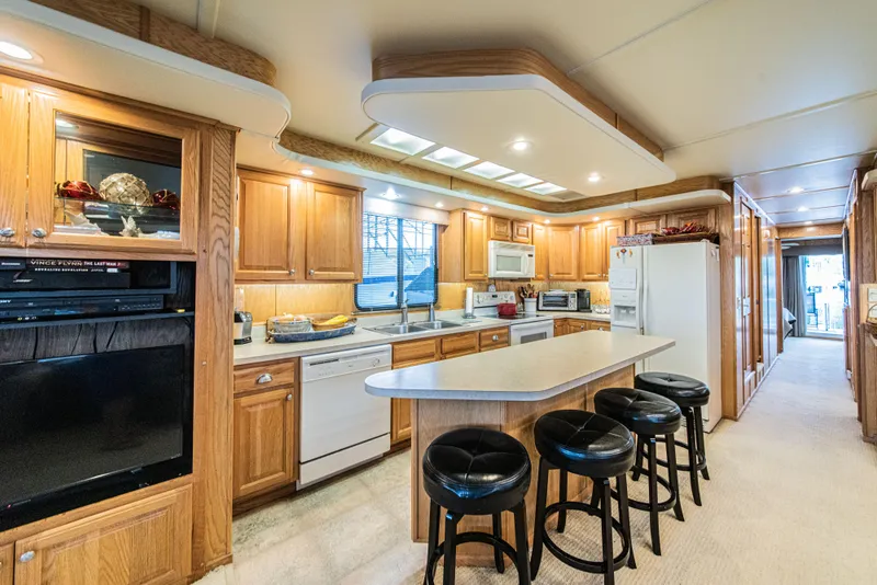 Slide: The Image of Luxurious 2002 Sumerset 75 houseboat kitchen with wooden cabinets and modern appliances. - 24