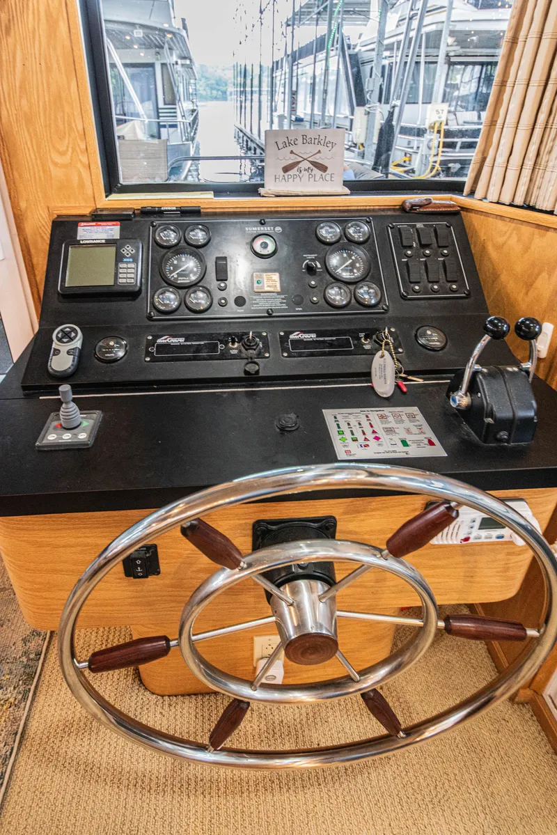 Slide: The Image of Control panel of a 2002 Sumerset 75 houseboat with steering wheel and navigation instruments. - 26