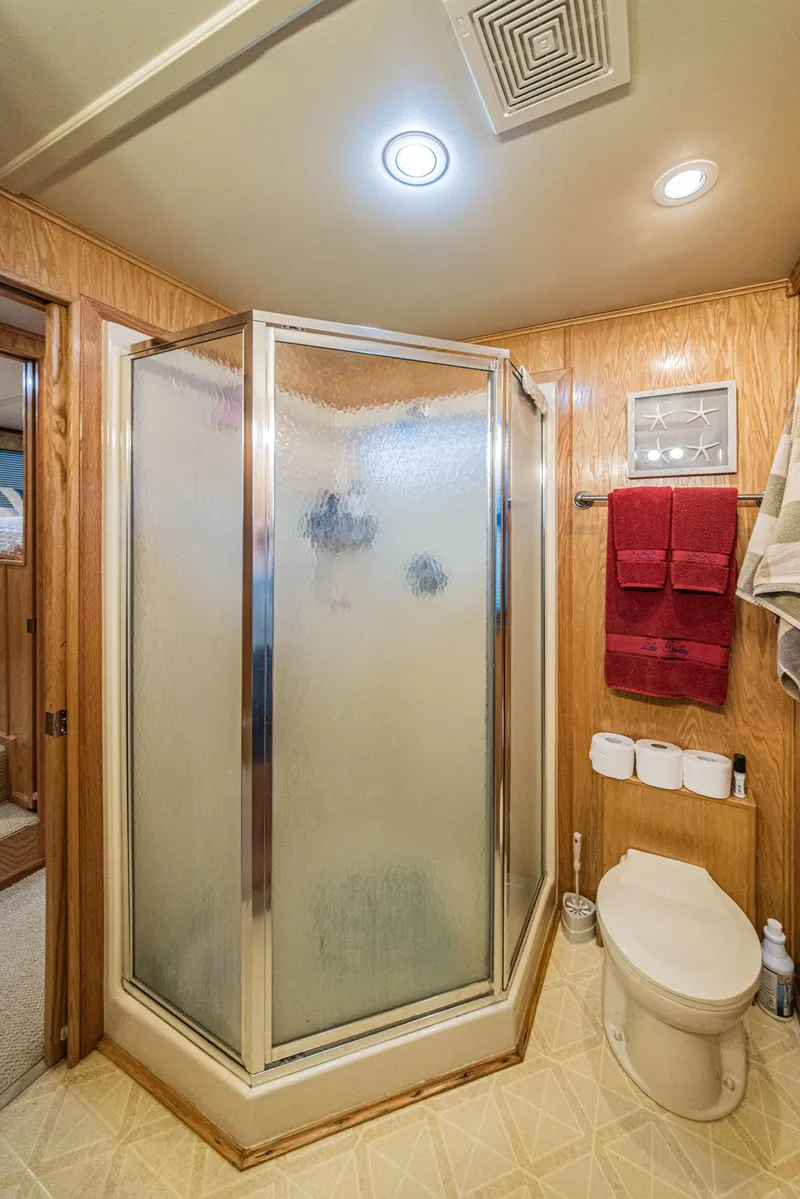 Slide: The Image of Bathroom in 2002 Sumerset 75 houseboat with shower, toilet, and wooden paneling. - 28