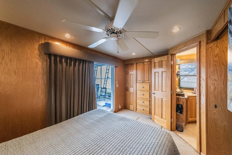 Slide: The Image of Interior of 2002 Sumerset 75 houseboat bedroom with wood paneling and ceiling fan. - 36