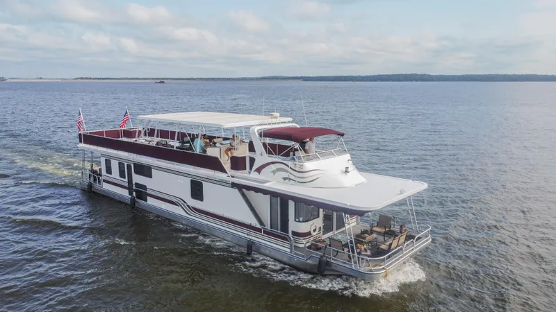 Slide: The Image of 2002 Sumerset 75 houseboat cruising on a calm lake under a cloudy sky. - 4