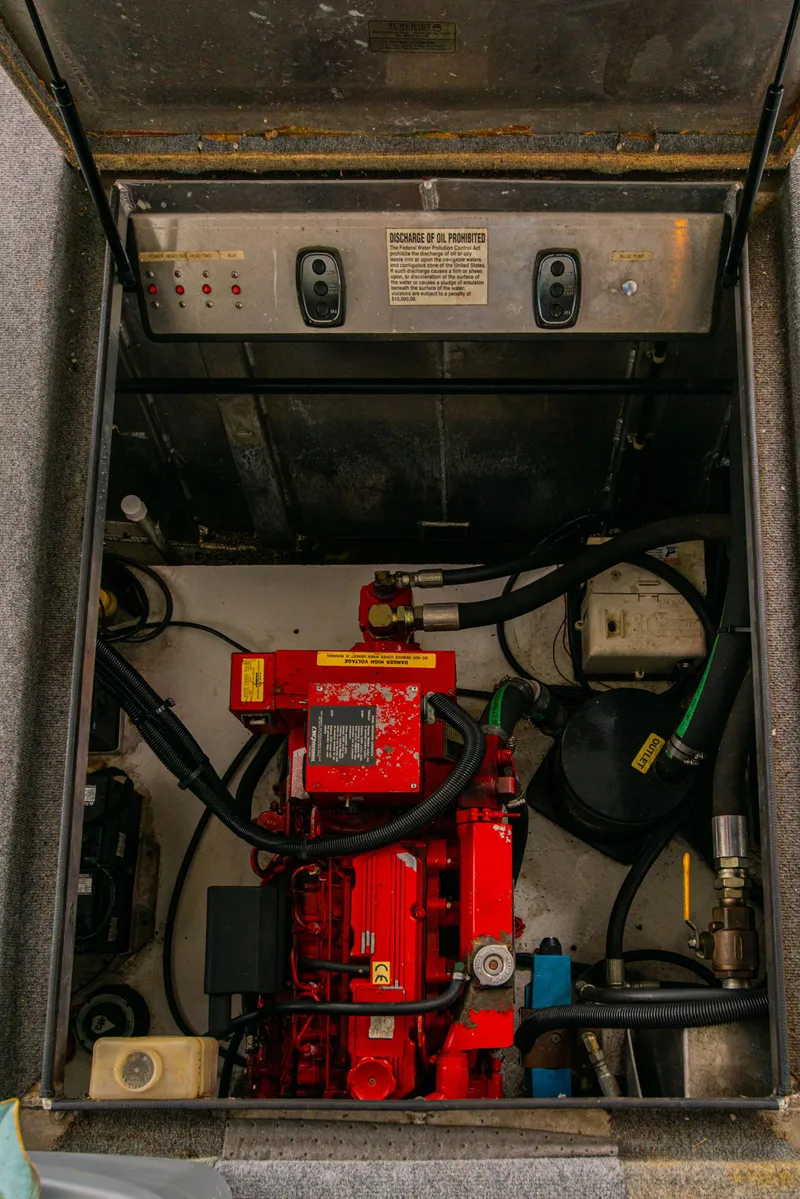 Slide: The Image of Engine compartment of a 2002 Sumerset 75 houseboat with visible red machinery and control panel. - 42