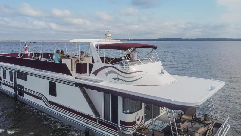 Slide: The Image of 2002 Sumerset 75 houseboat cruising on a calm lake under a cloudy sky. - 5