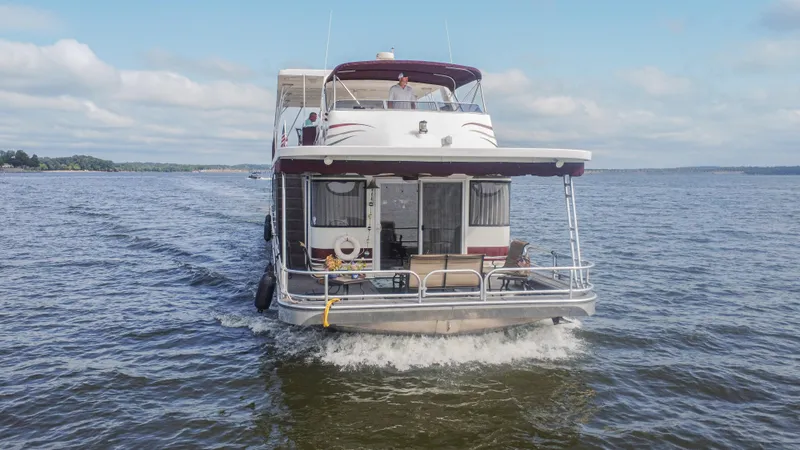 Slide: The Image of 2002 Sumerset 75 houseboat cruising on a lake under a clear sky. - 7