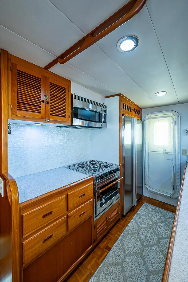 Slide: The Image of 2001 Kadey-Krogen 58 yacht kitchen with wooden cabinets and modern appliances. - 13