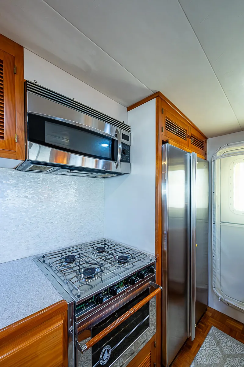 Slide: The Image of 2001 Kadey-Krogen 58 yacht kitchen with stainless steel appliances and wooden cabinetry. - 14