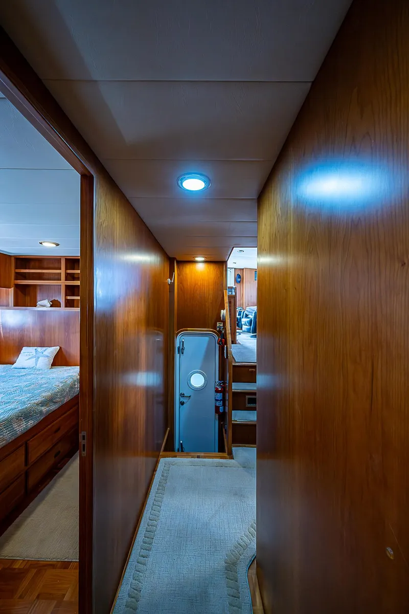 Slide: The Image of Hallway inside 2001 Kadey-Krogen 58 yacht, featuring wooden paneling and cozy bedroom view. - 33