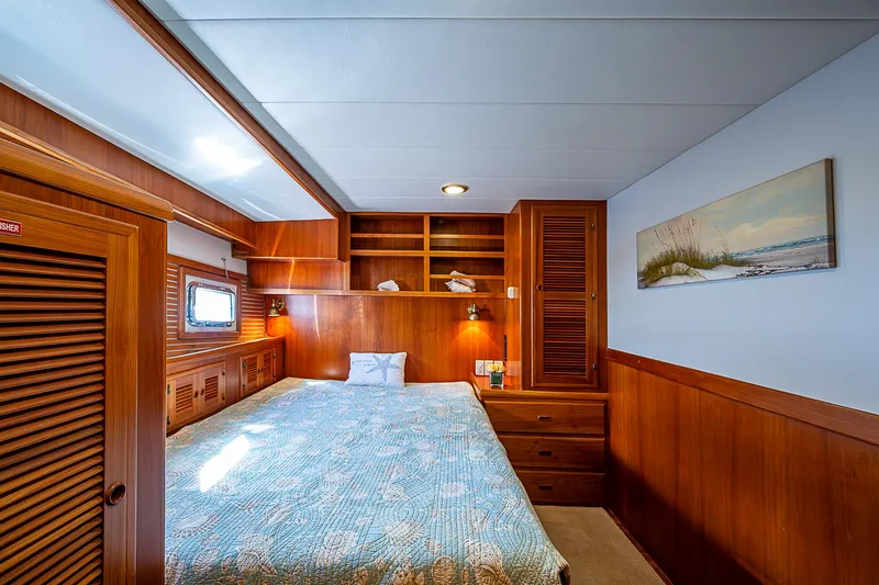 Slide: The Image of Luxurious wood-paneled bedroom in 2001 Kadey-Krogen 58 yacht with cozy bed and storage. - 36