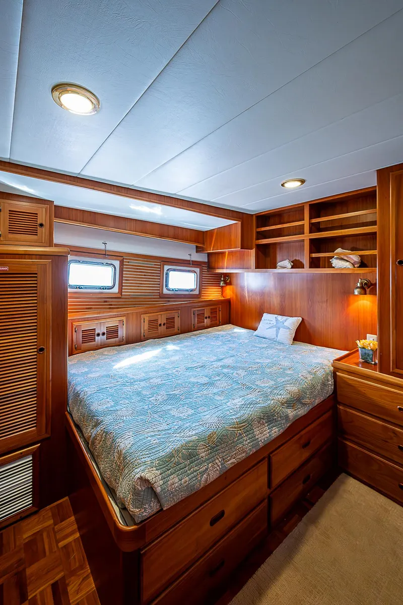 Slide: The Image of Luxurious wood-finished bedroom in 2001 Kadey-Krogen 58 yacht, featuring ample storage and cozy lighting. - 38