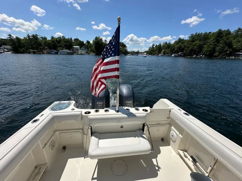 Slide: The Image of 2016 Sailfish 270 CC boat with American flag on a lake. - 10