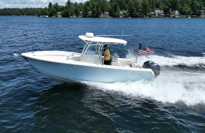Slide: The Image of 2016 Sailfish 270 CC boat cruising on a lake with an American flag. - 18