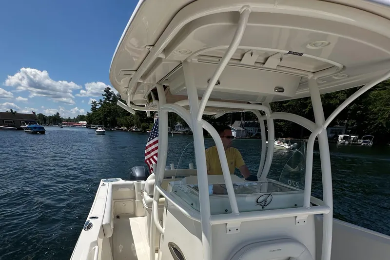 Slide: The Image of 2016 Sailfish 270 CC boat cruising on a sunny day with an American flag. - 22
