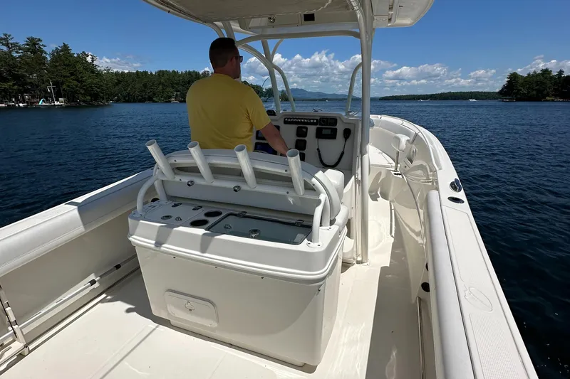 Slide: The Image of 2016 Sailfish 270 CC boat on a lake with a person at the helm. - 24
