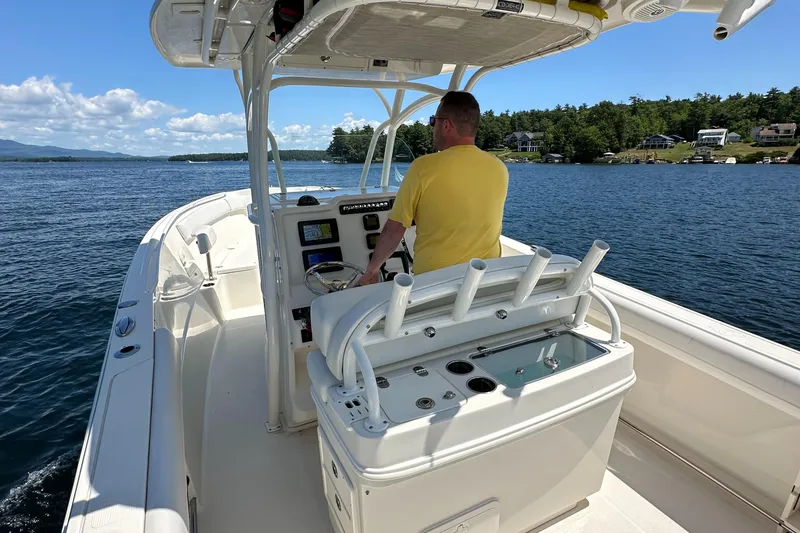 Slide: The Image of Man steering 2016 Sailfish 270 CC boat on a sunny lake. - 25