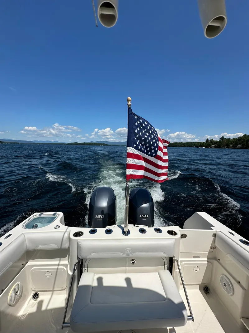 Slide: The Image of 2016 Sailfish 270 CC boat with American flag on open water. - 28