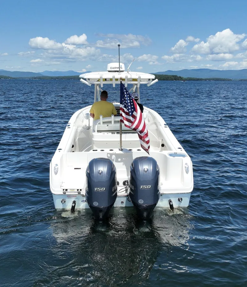 Slide: The Image of 2016 Sailfish 270 CC boat on open water with American flag. - 4