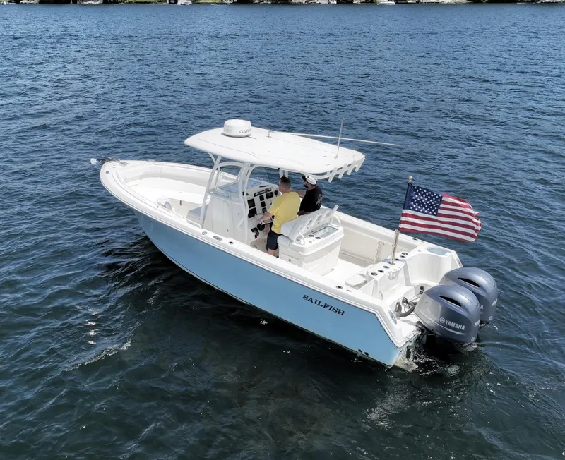 Slide: The Image of 2016 Sailfish 270 CC boat on water with American flag and twin outboard motors. - 6