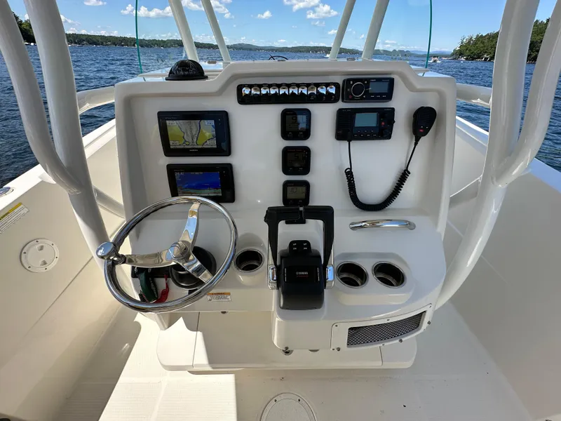 Slide: The Image of 2016 Sailfish 270 CC boat console with steering wheel, navigation screens, and controls. - 8