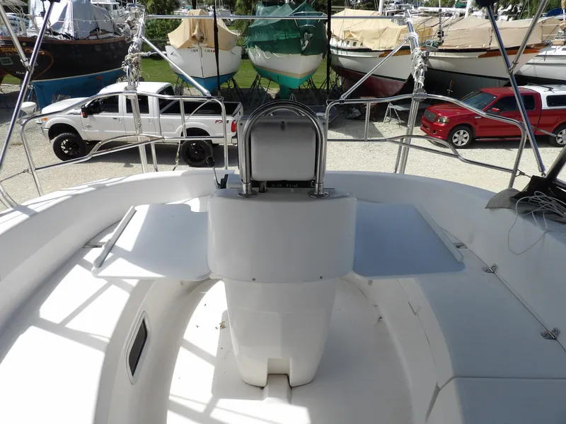 Slide: The Image of Cockpit view of a 2000 Hunter 460 sailboat with docked boats and vehicles in the background. - 25