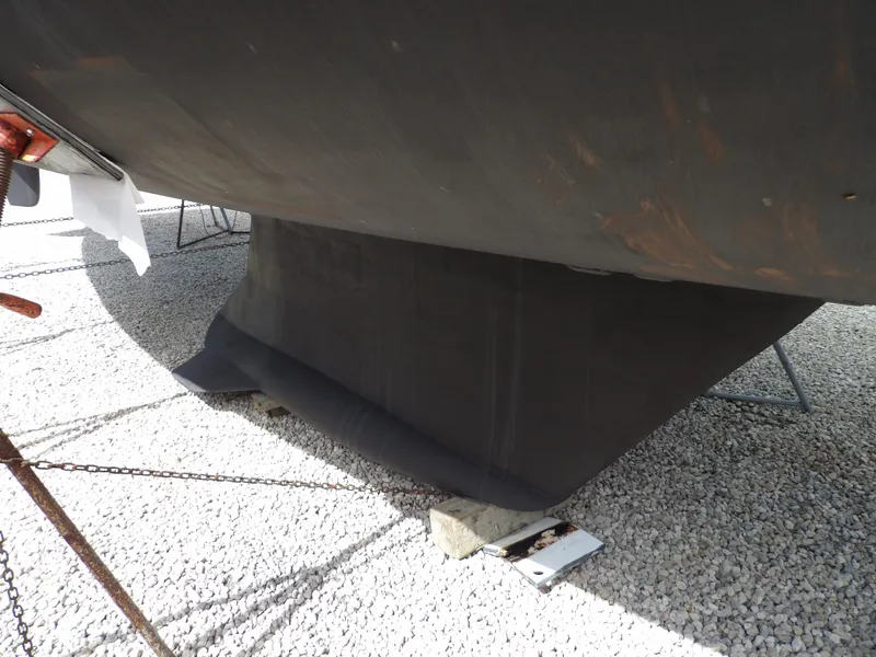 Slide: The Image of Hunter 460 2000 sailboat keel on gravel lot. - 7