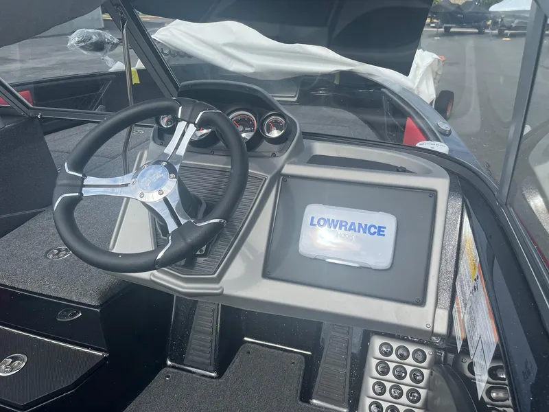 Slide: The Image of 2025 Ranger 1880MS boat dashboard with Lowrance display and steering wheel. - 2