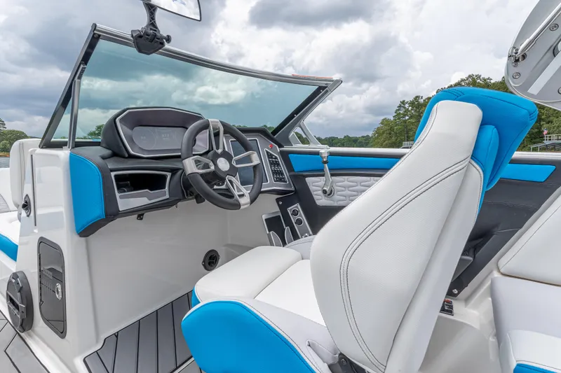 Slide: The Image of 2019 MasterCraft X24 boat interior with blue and white seating, modern dashboard, and steering wheel. - 24