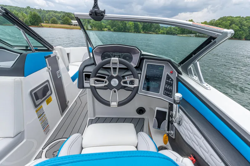 Slide: The Image of 2019 MasterCraft X24 boat cockpit with modern steering and controls on a lake. - 25