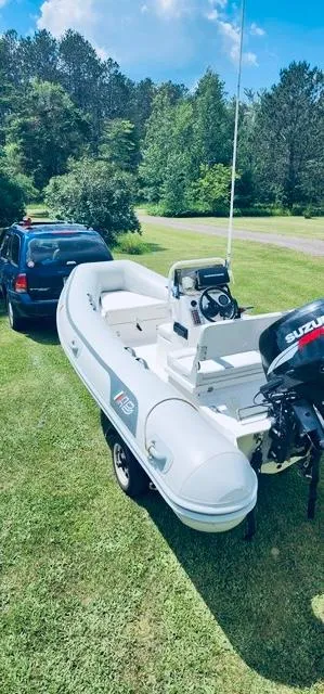 Slide: The Image of 2004 AB Inflatables Oceanus 4.30VST boat on trailer, parked on grass, with a car nearby. - 1