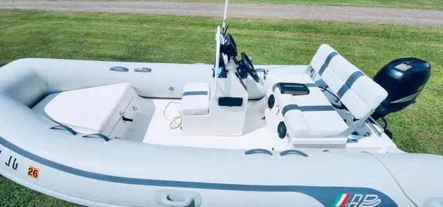 Slide: The Image of 2004 AB Inflatables Oceanus 4.30VST boat on grass, featuring seating and steering console. - 4