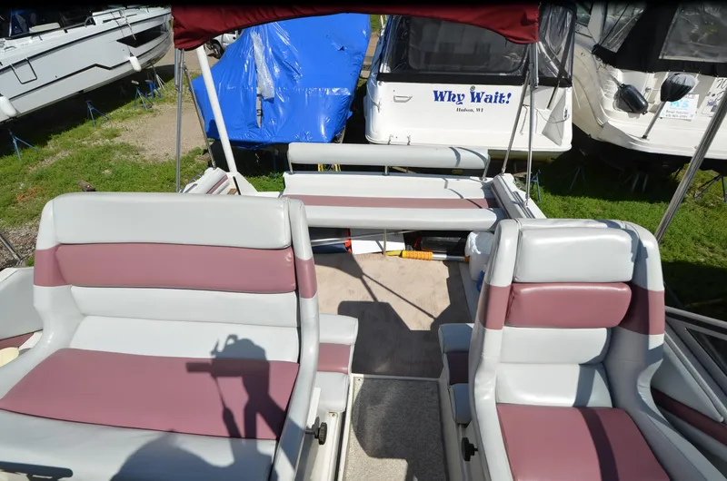 Slide: The Image of 1988 Carver 27 Montego boat interior with maroon and gray seating, docked outdoors. - 11