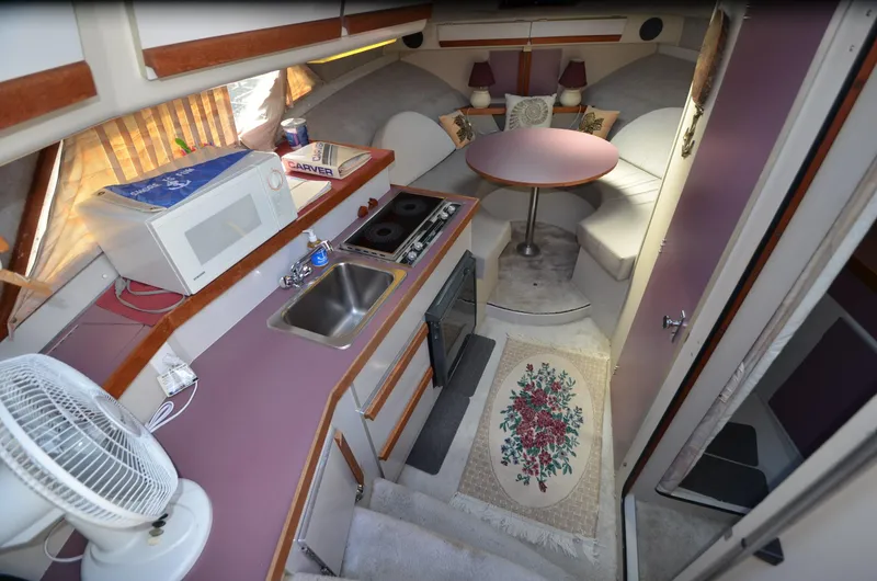 Slide: The Image of 1988 Carver 27 Montego interior with kitchenette, dining area, and cozy seating. - 15