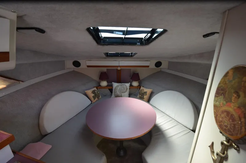Slide: The Image of Interior of 1988 Carver 27 Montego boat with cozy seating and table. - 19