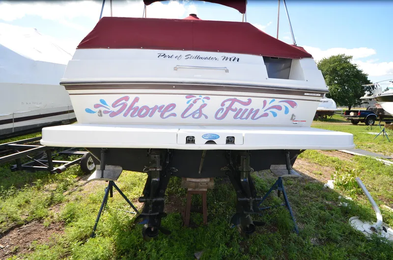 Slide: The Image of 1988 Carver 27 Montego boat with "Shore is Fun" text, parked on grass. - 2