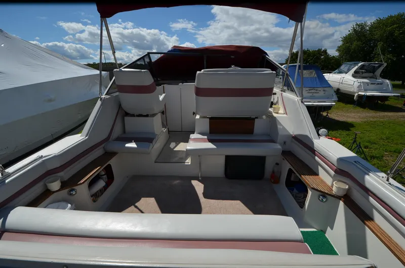 Slide: The Image of 1988 Carver 27 Montego boat interior with seating and canopy, docked outdoors. - 5