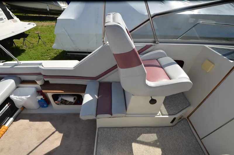 Slide: The Image of 1988 Carver 27 Montego boat interior with cushioned seating and storage compartments. - 6
