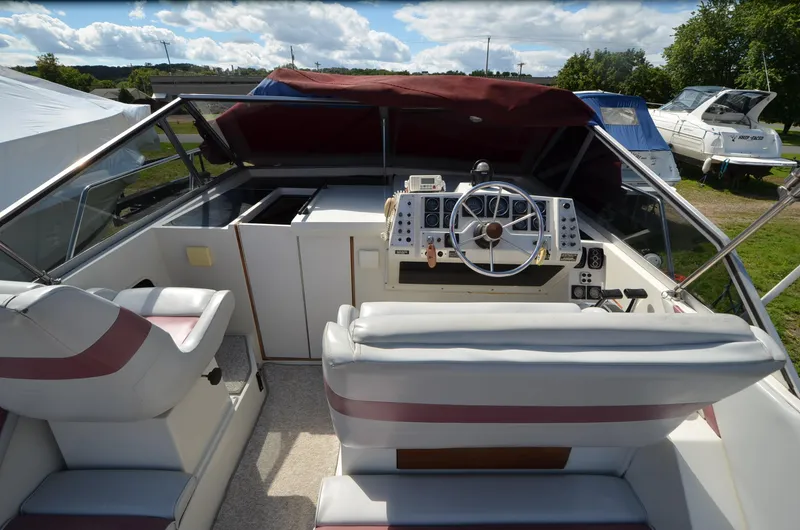 Slide: The Image of 1988 Carver 27 Montego boat interior with steering wheel and seating area. - 7