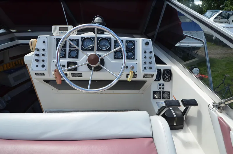 Slide: The Image of 1988 Carver 27 Montego boat dashboard with steering wheel and control panel. - 9