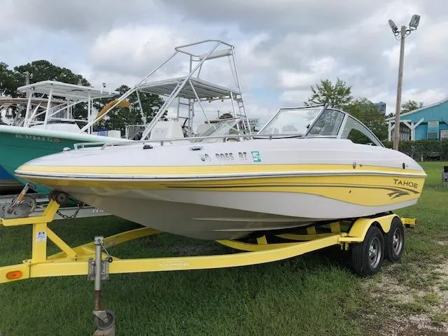 The Image of 2005 Tahoe Q4 I/O boat on a yellow trailer, parked on grass. - 1