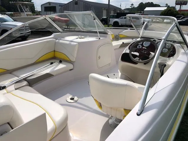 Slide: The Image of 2005 Tahoe Q4 I/O boat interior with white and yellow seating, steering wheel, and dashboard. - 12