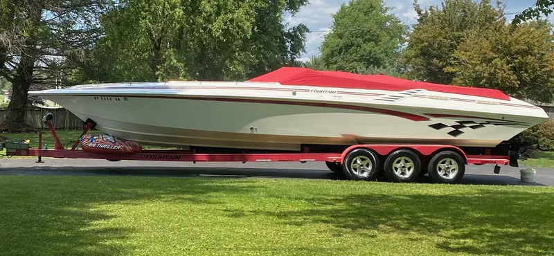 Slide: The Image of 2001 Fountain Lightning Executioner 35 speedboat on a red trailer, parked on a driveway. - 0
