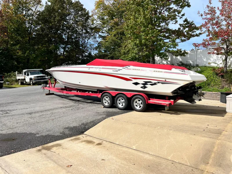 Slide: The Image of 2001 Fountain Lightning Executioner 35 boat on a red trailer, parked outdoors. - 18