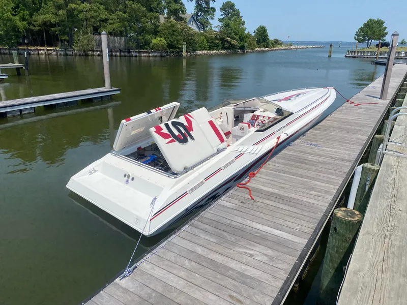 Slide: The Image of 2001 Fountain Lightning Executioner 35 speedboat docked on a calm lake. - 2