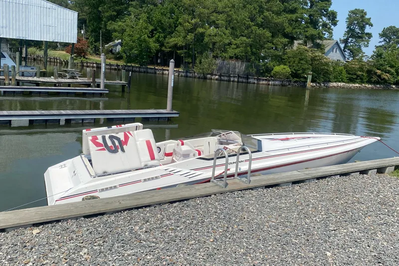 Slide: The Image of 2001 Fountain Lightning Executioner 35 speedboat docked by a lakeside. - 24